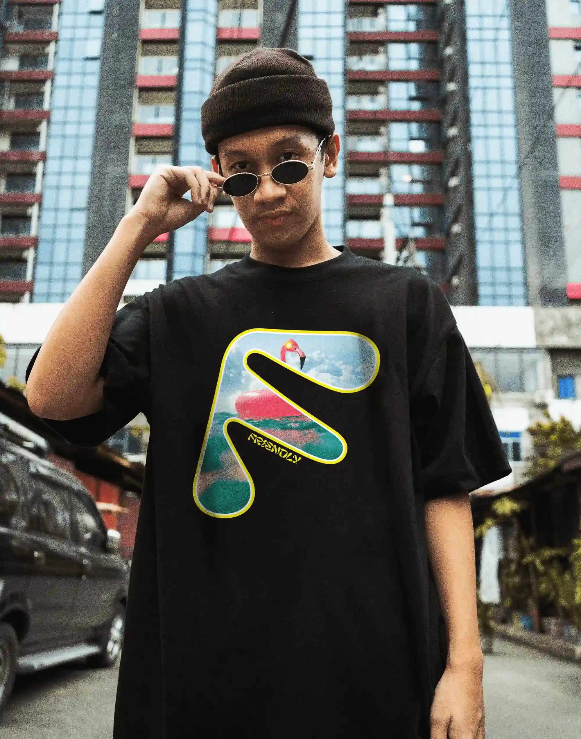 Man with glasses on the street wearing a Friendly Gear t-shirt.